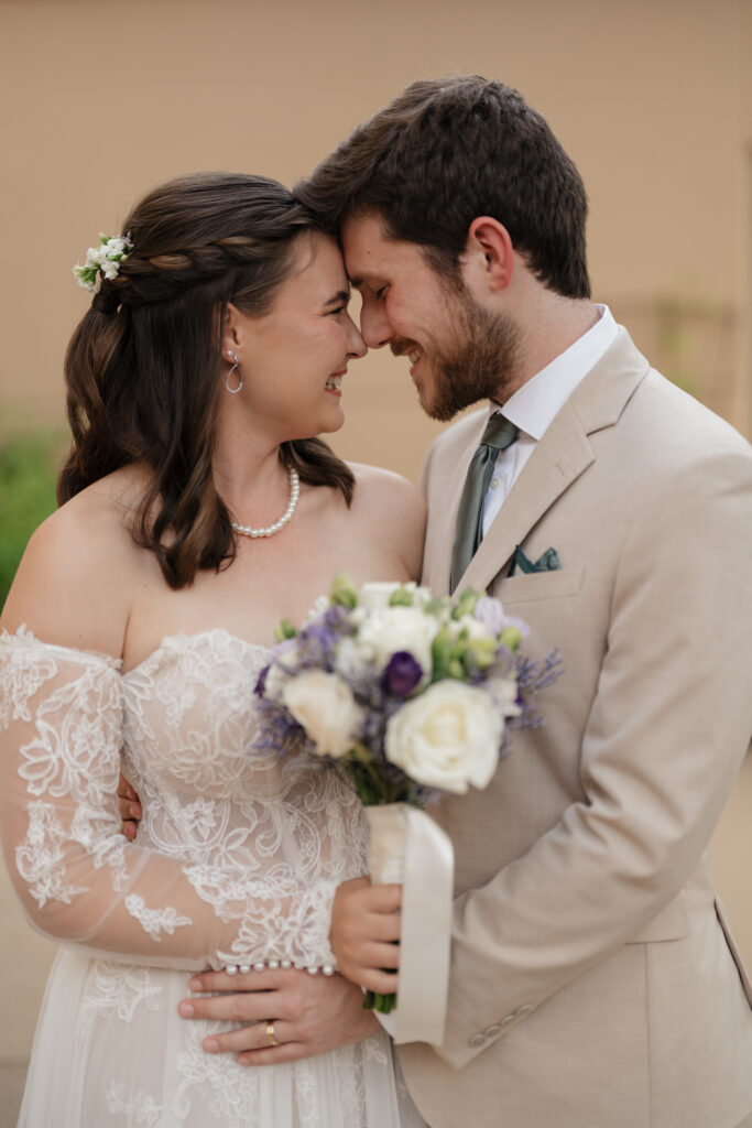 Bride and groom touching heads during family photos, captured by an Atlanta wedding photo and video team