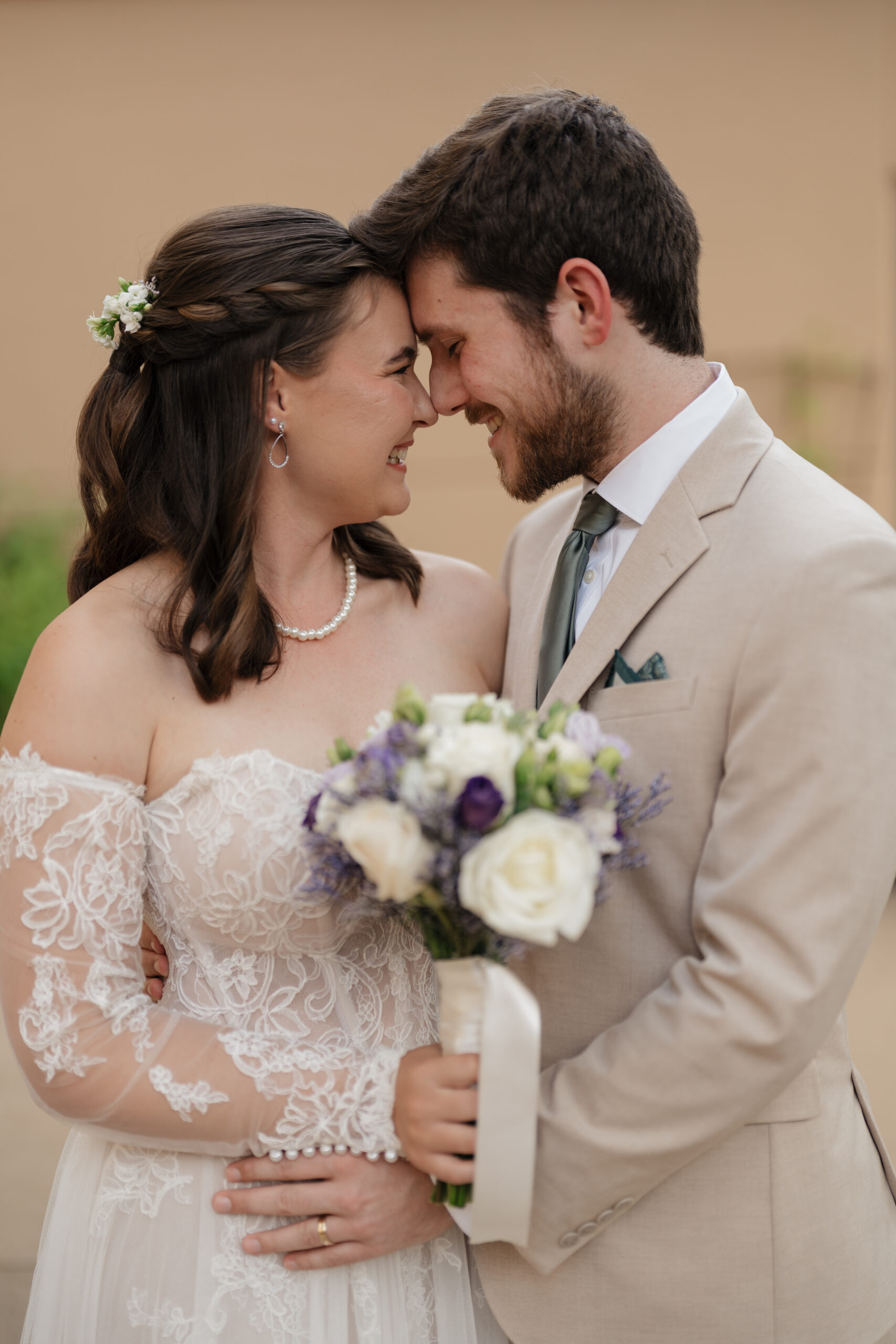 Bride and groom touching heads during family photos, captured by an Atlanta wedding photo and video team