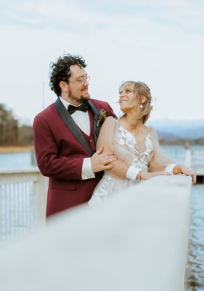 bride and groom posing at the ridges after getting married on the dock