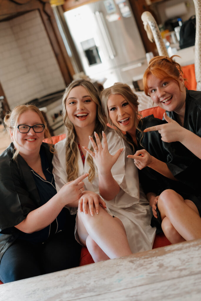 Bride showing off ring with her bridesmaids in Bridal suite at West Milford Farm