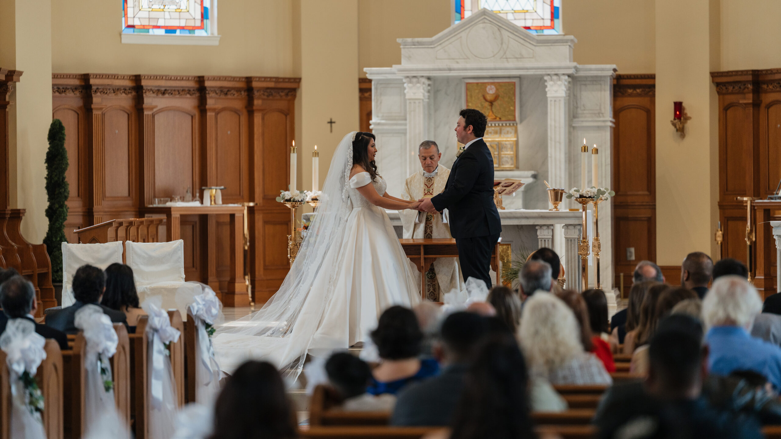 Bride and Groom holding hands at the alter at St.Benedict Catholic Church in John's Creek, Georgia
