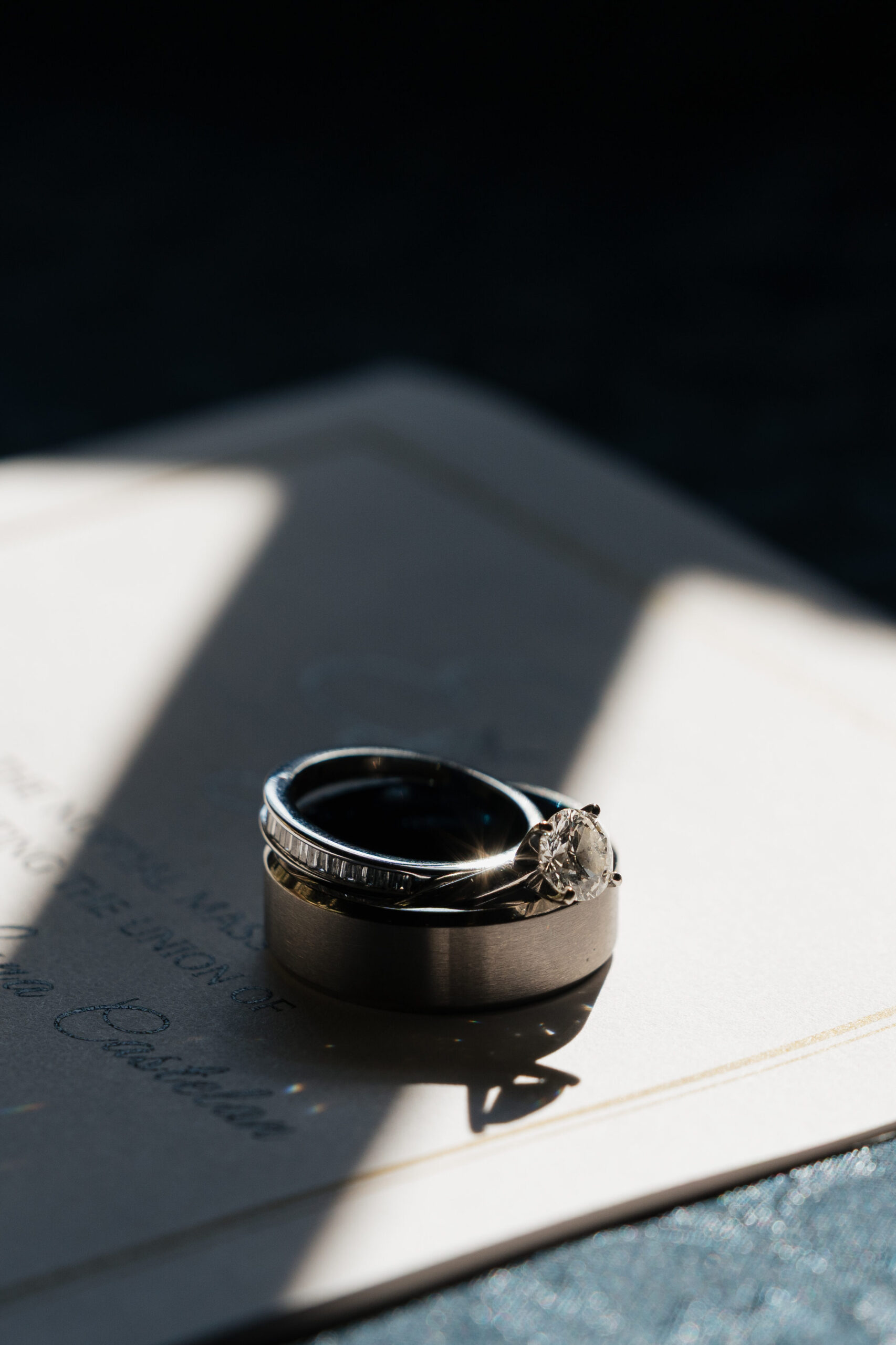 Wedding Rings over on top of a Catholic wedding invitation at St.Benedict Catholic Church in John's Creek, Georgia