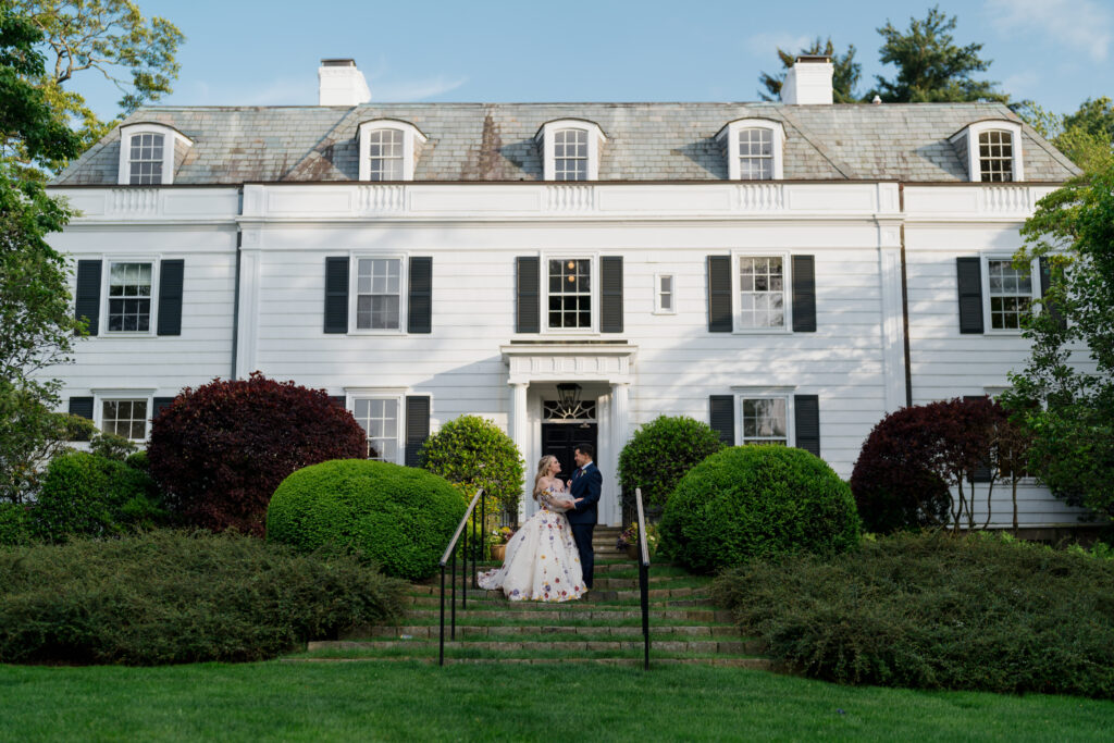 Bride and Groom standing outside of The Meadowlands at the Darien Community Association.