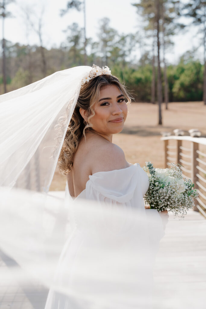 Wedding photo of bride posing on the bridge at Mystic Acres wedding venue in Griffin, GA.