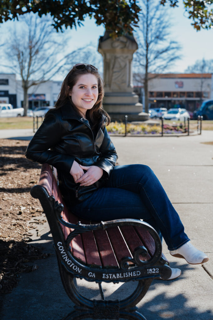 Wedding photographer sitting on a bench in Covington Square in Covington, GA