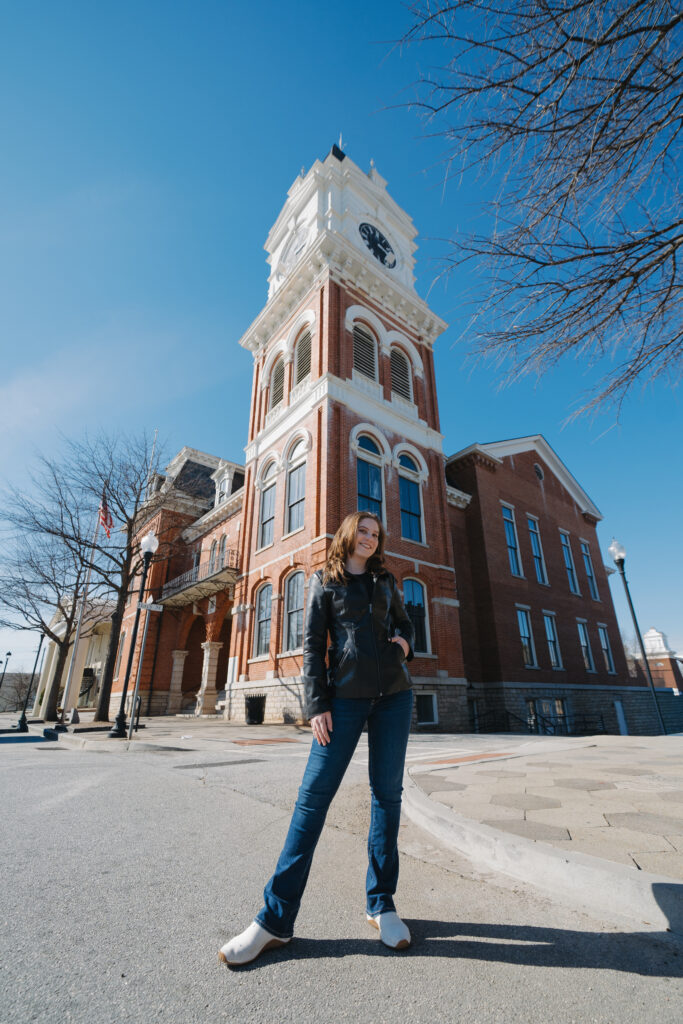 Wedding photographer standing in front of the Covington Square clocktower in Covington, GA