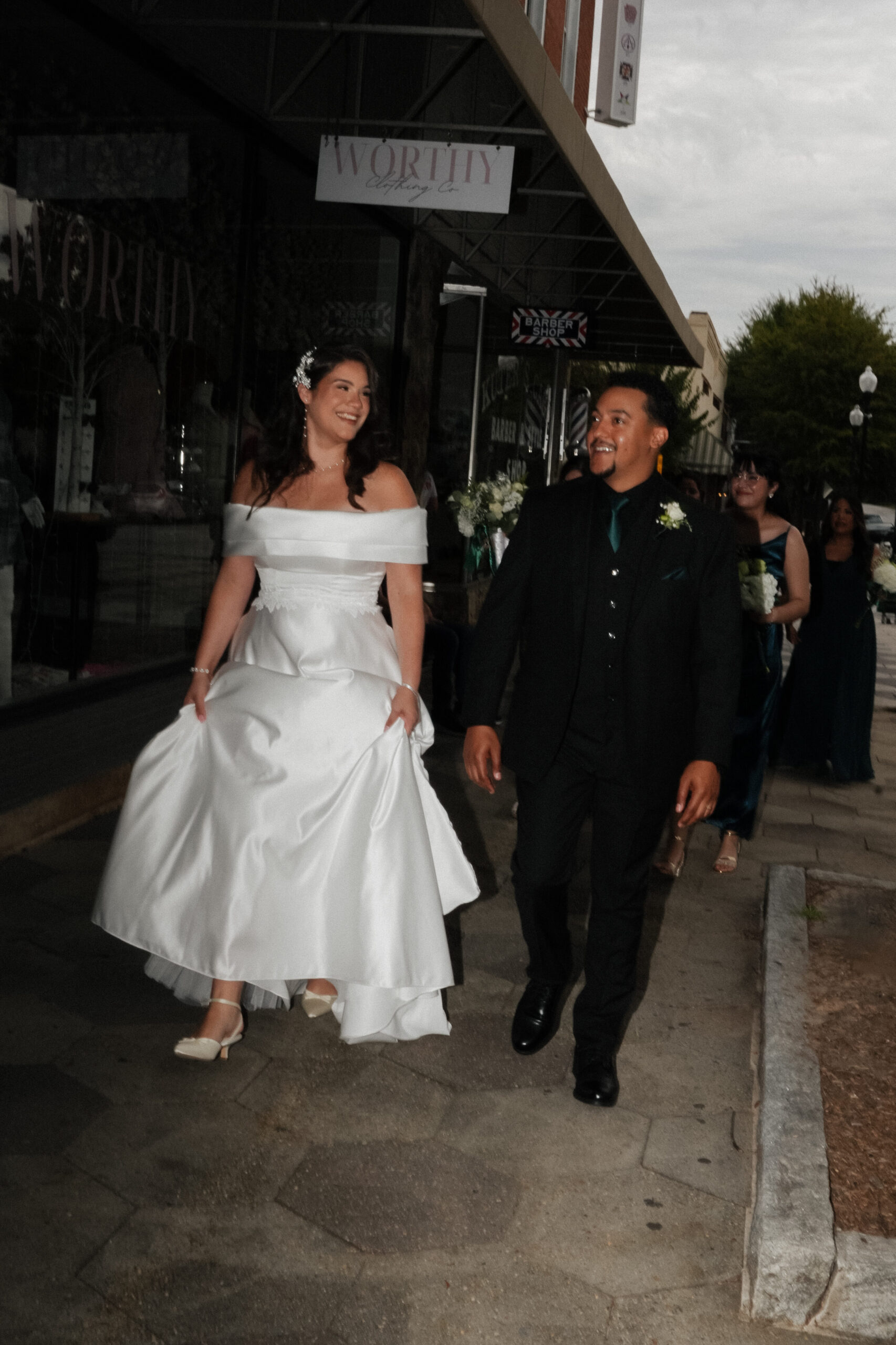 Bride and groom walking through Covington Square during wedding portraits