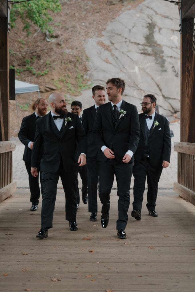 groom with groomsman at roswell mill water fall for pre-wedding photos